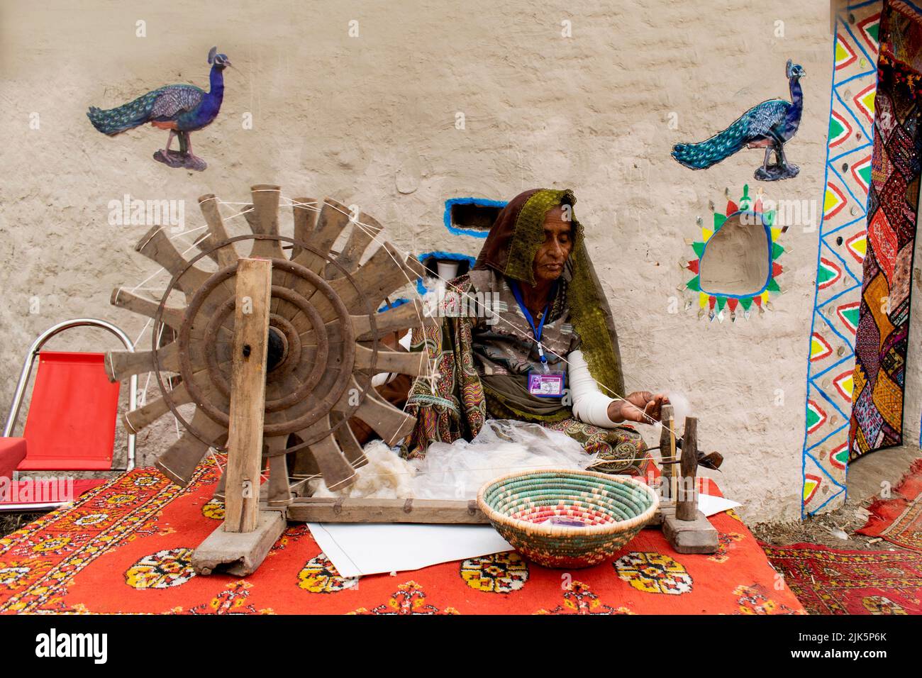Eine alte Frau demonstriert Fadenherstellung auf Charkha, Spinning Wheal während Lok Mela , Islamabad Stockfoto