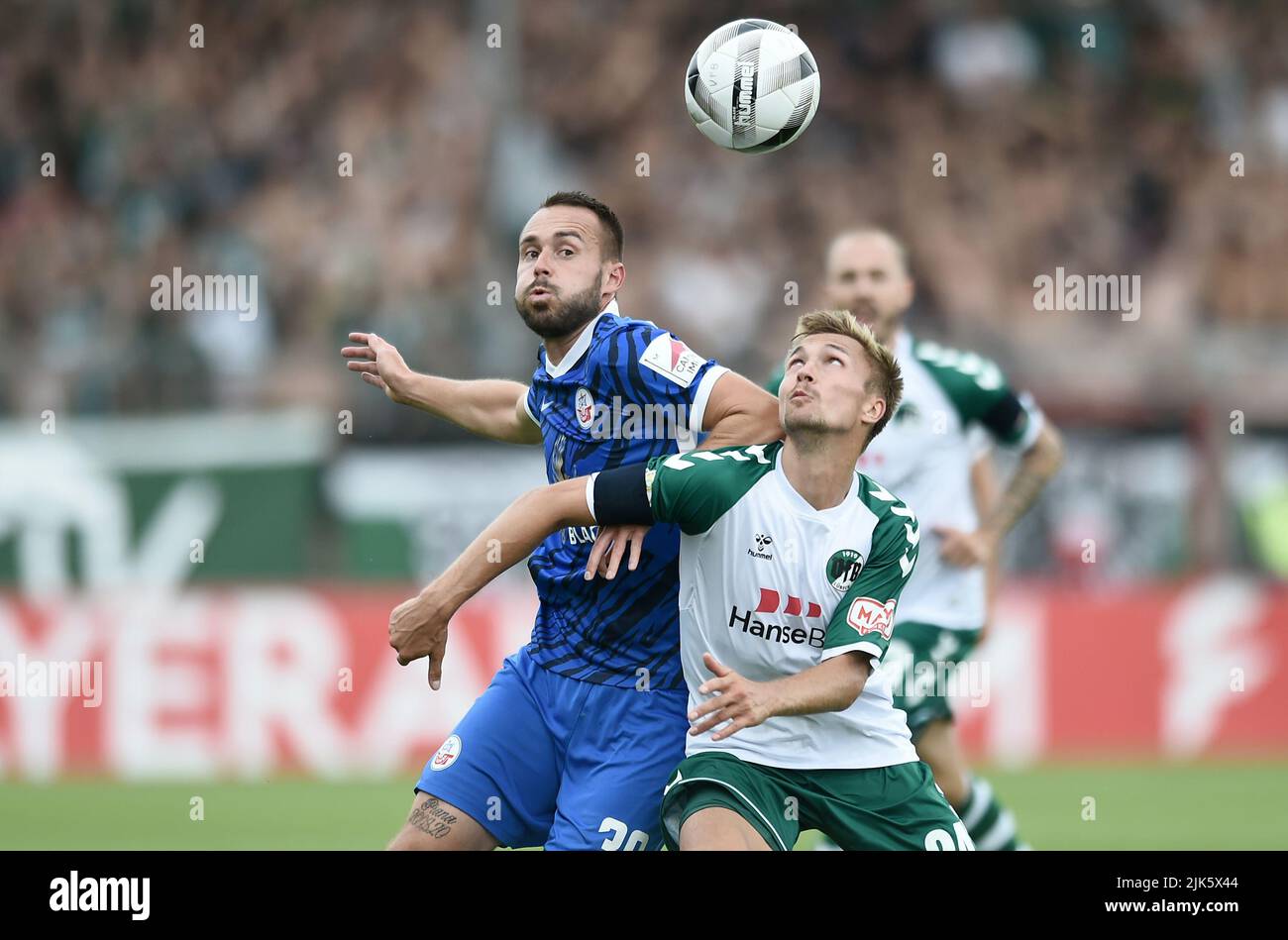 30. Juli 2022, Schleswig-Holstein, Lübeck: Fußball: DFB-Pokal, VfB Lübeck - Hansa Rostock 1. Runde im Stadion an der Lohmühle: Rostocks Theo Martens (l.) und Lübecks Morten Rüdiger im Duell. Foto: Michael Schwartz/dpa - WICHTIGER HINWEIS: Gemäß den Anforderungen der DFL Deutsche Fußball Liga und des DFB Deutscher Fußball-Bund ist es untersagt, im Stadion und/oder des Spiels aufgenommene Fotos in Form von Sequenzbildern und/oder videoähnlichen Fotoserien zu verwenden oder zu verwenden. Stockfoto