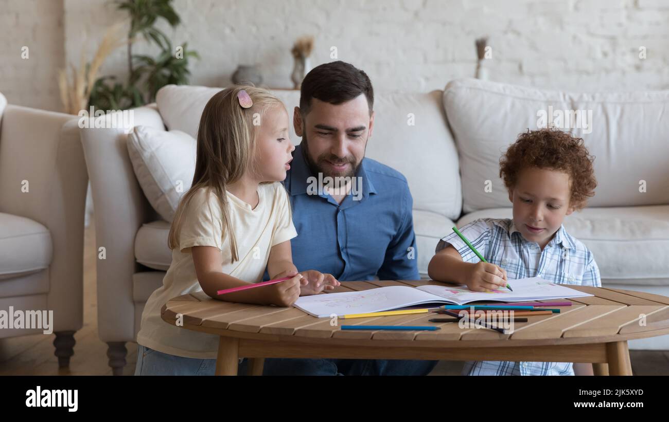 Glücklicher Vater, der kreative Freizeit mit zwei Geschwisterkindern genießt Stockfoto