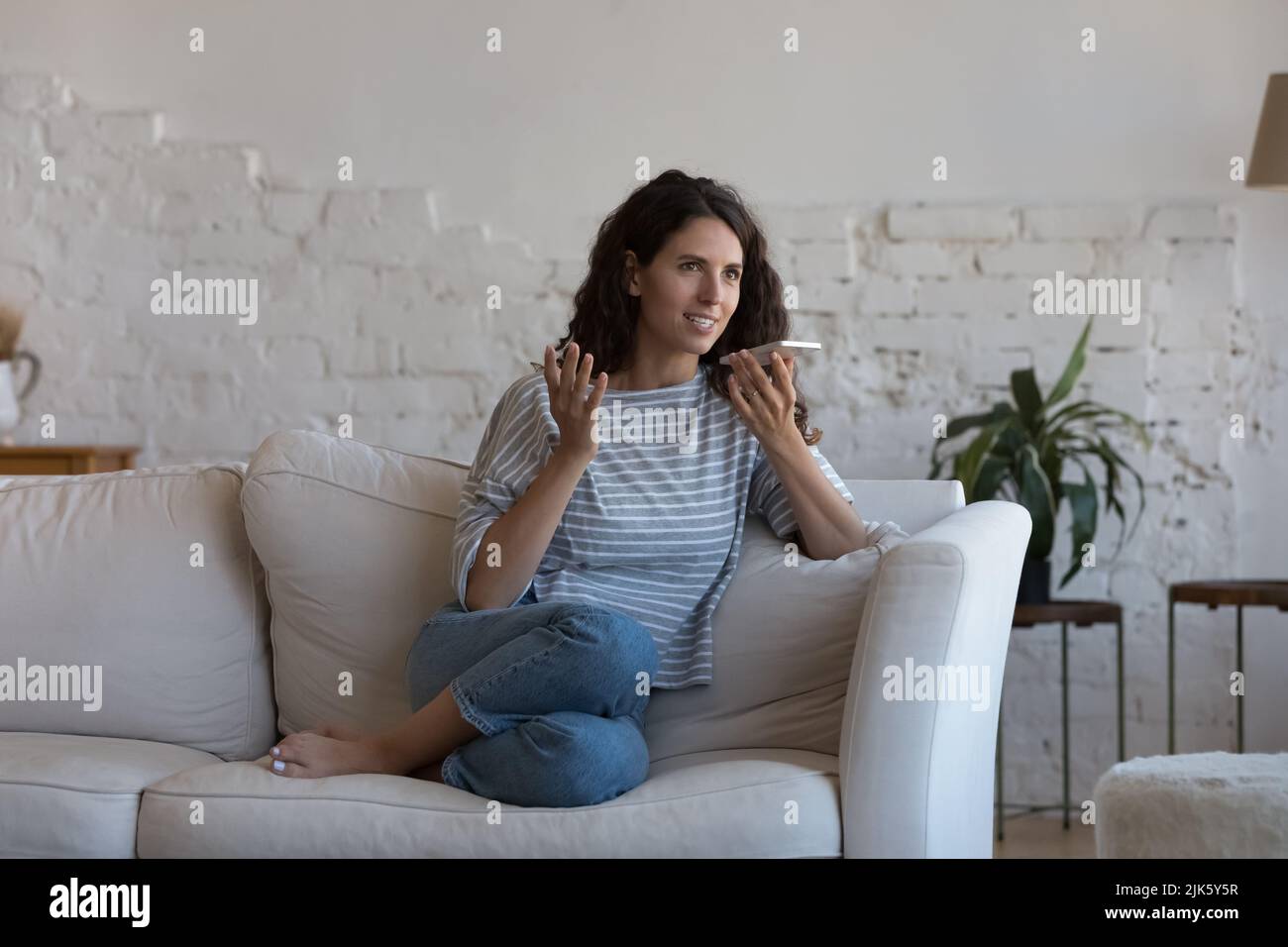Glückliche Handybenutzerin, die über den Lautsprecher telefoniert Stockfoto