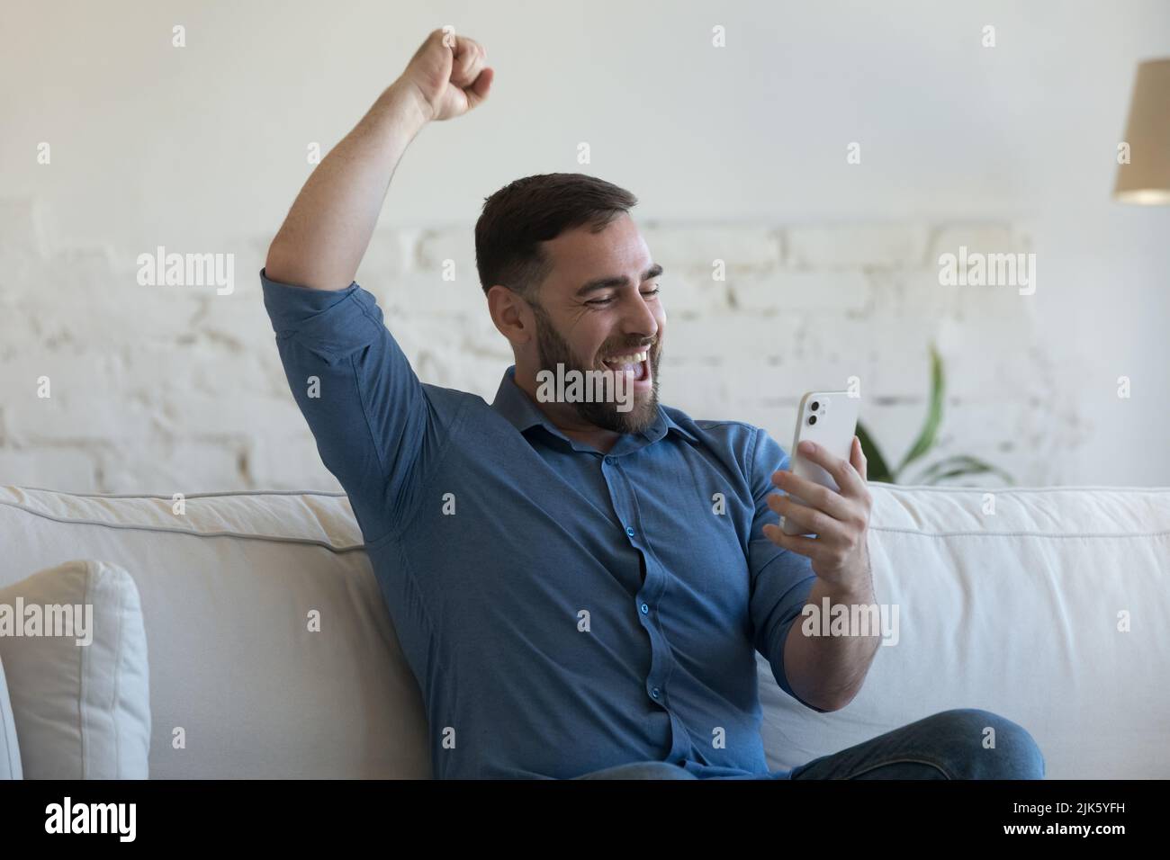 Aufgeregt glücklich Smartphone-Benutzer Kerl lernen gute Nachrichten Stockfoto