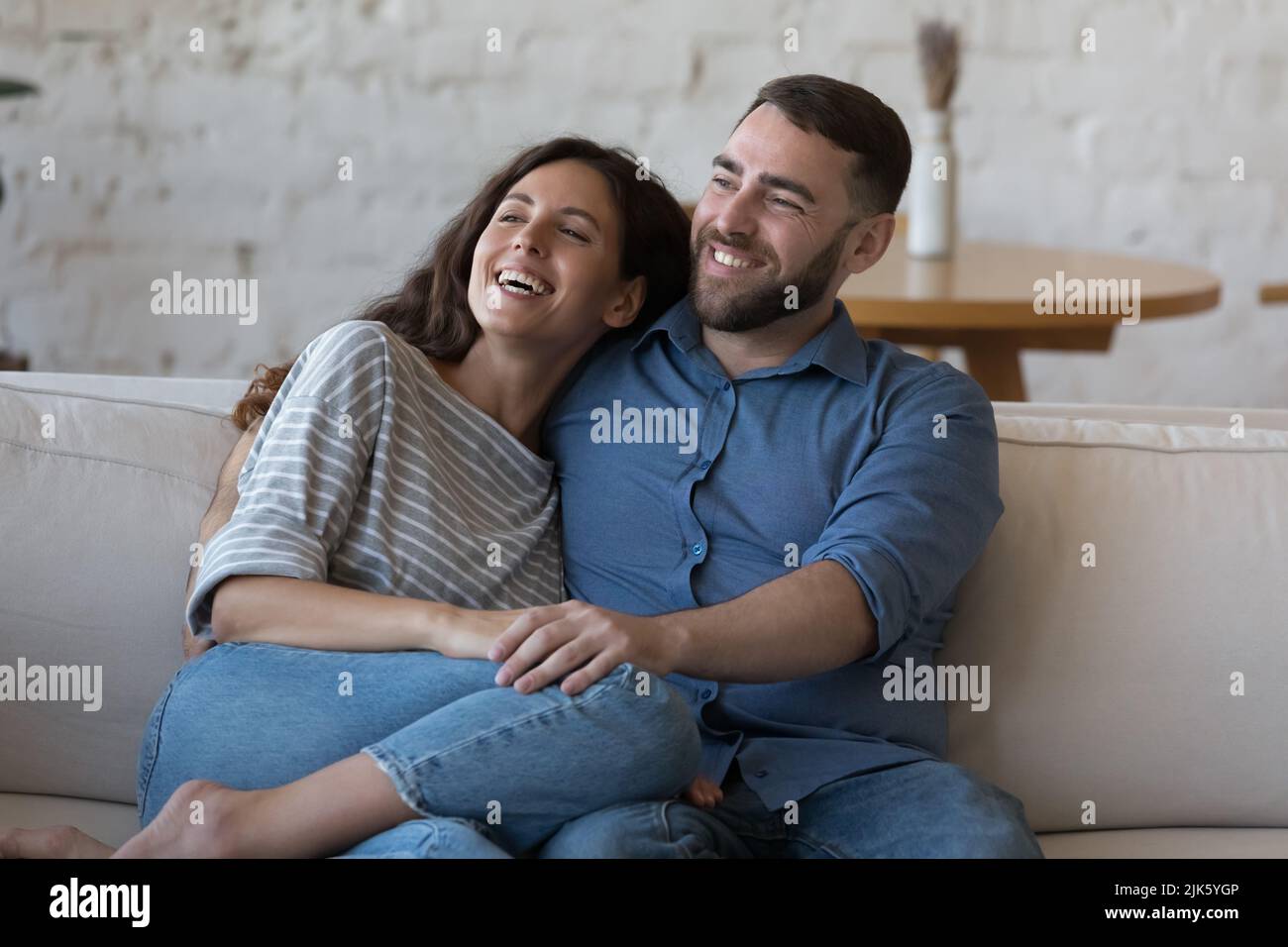 Glückliches junges erwachsenes Paar in der Liebe, genießen Freizeit auf der Couch Stockfoto