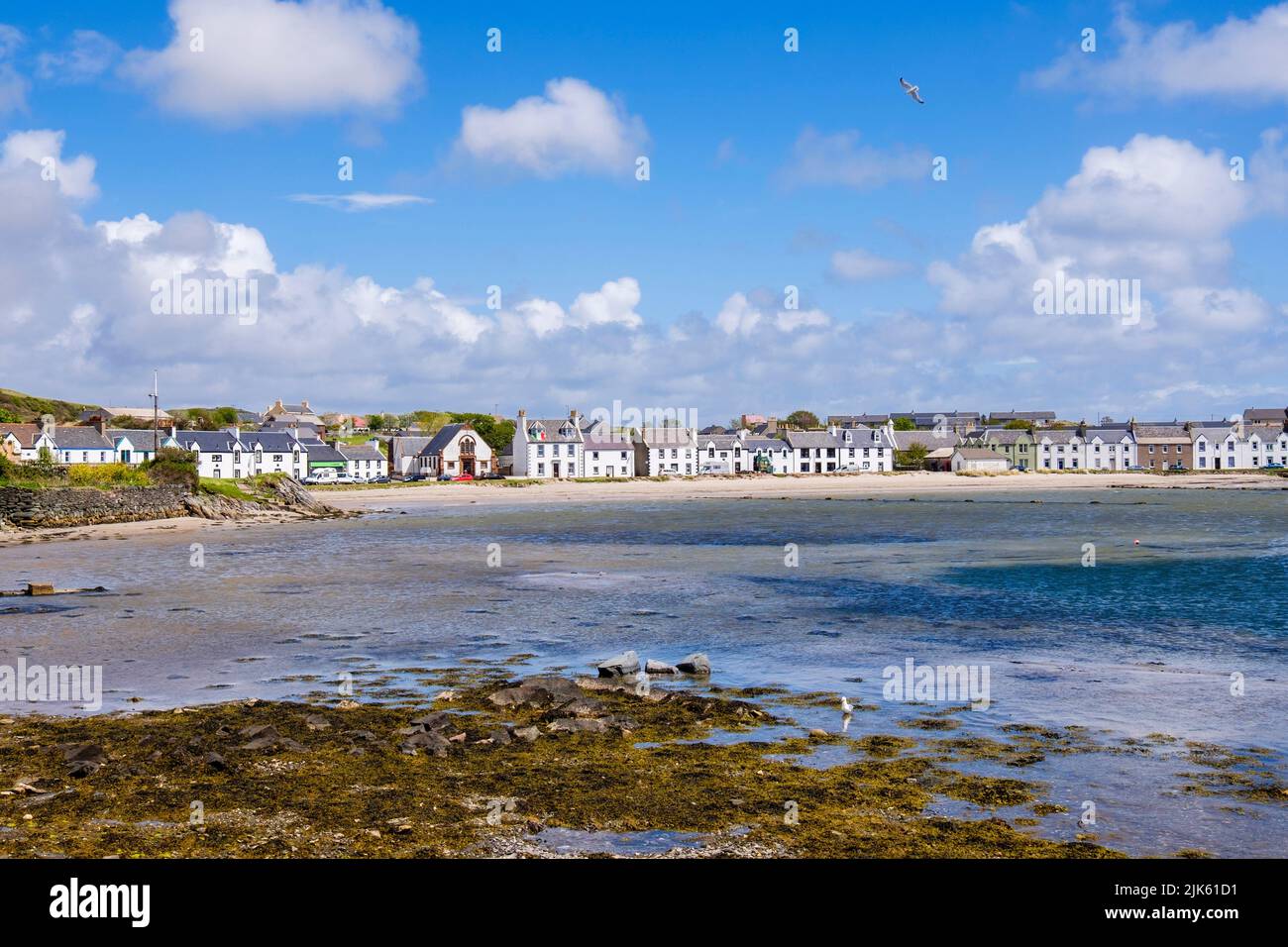 Blick über die Leodamais Bay auf Häuser am Wasser. Port Ellen, Isle of Islay, Argyll and Bute, Inner Hebrides, Schottland, Großbritannien, Großbritannien Stockfoto