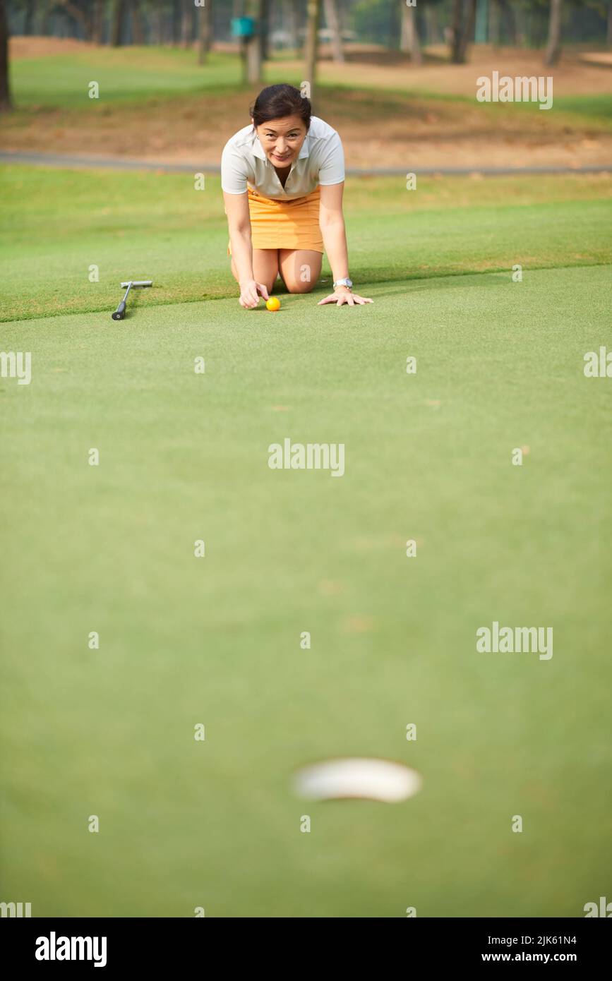 Weibliche Golfspielerin, die nach der besten Position für den Finishing Hit sucht Stockfoto