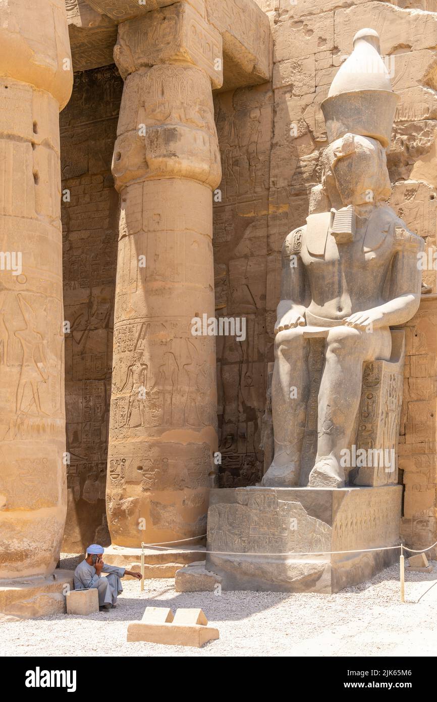 Luxor, Ägypten; 28. Juli 2022 - ein arabischer Mann sitzt am Eingang des Luxor-Tempels in Ägypten. Stockfoto