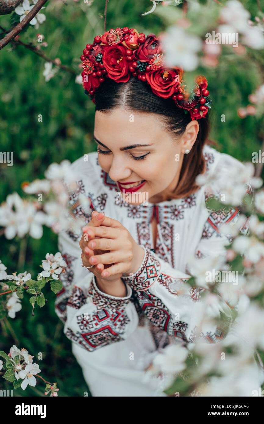Attraktive ukrainische Frau in traditionellen Stickerei vyschywanka Kleid und roten Blumen Kranz. Ukraine, Freiheit, Kultur, Nationalkostüm, Sieg in Stockfoto