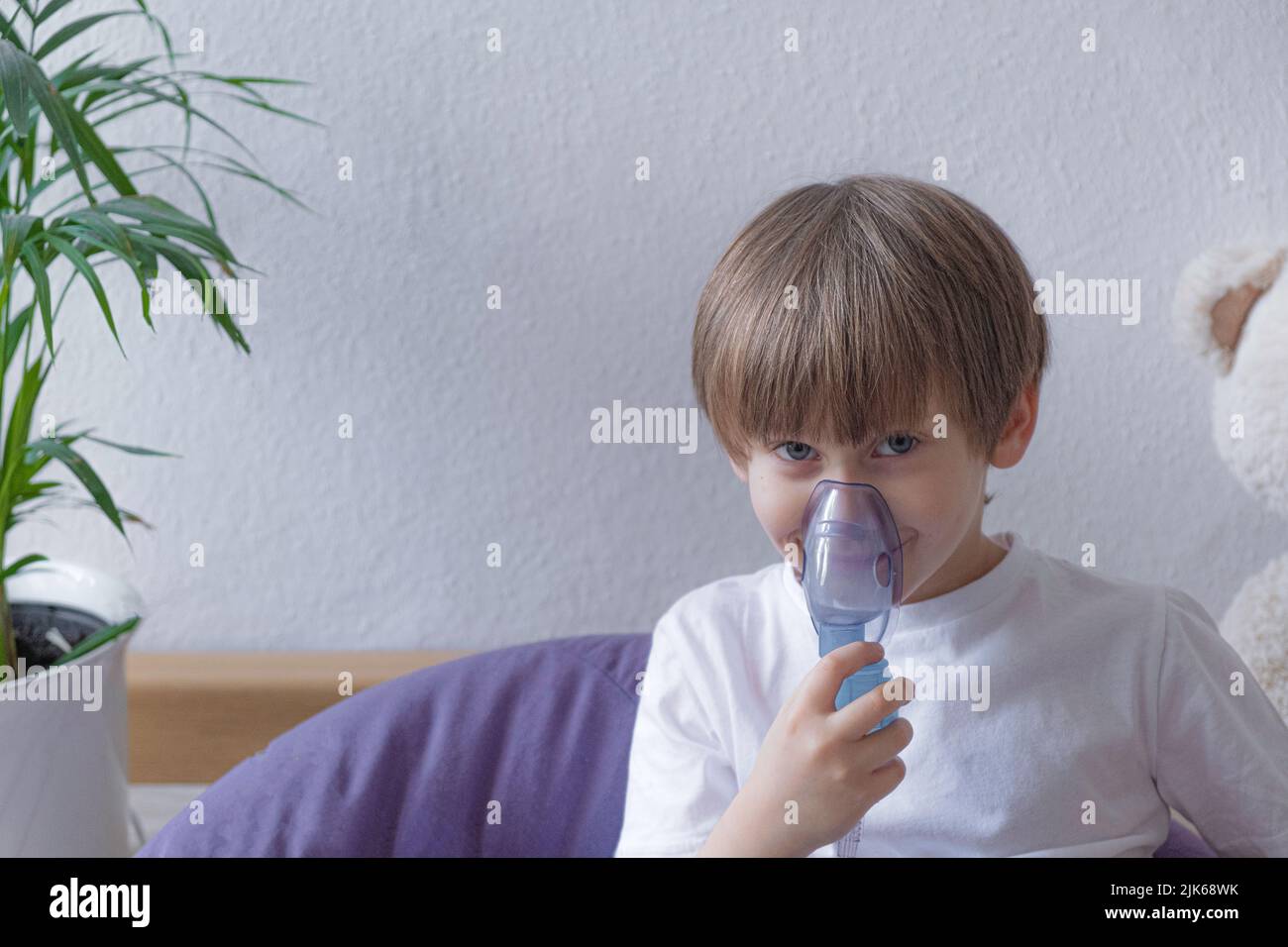 Unwell Kind mit Kammer Inhalator für Hustenbehandlung . Gesundheitswesen und Medikamente. Stockfoto