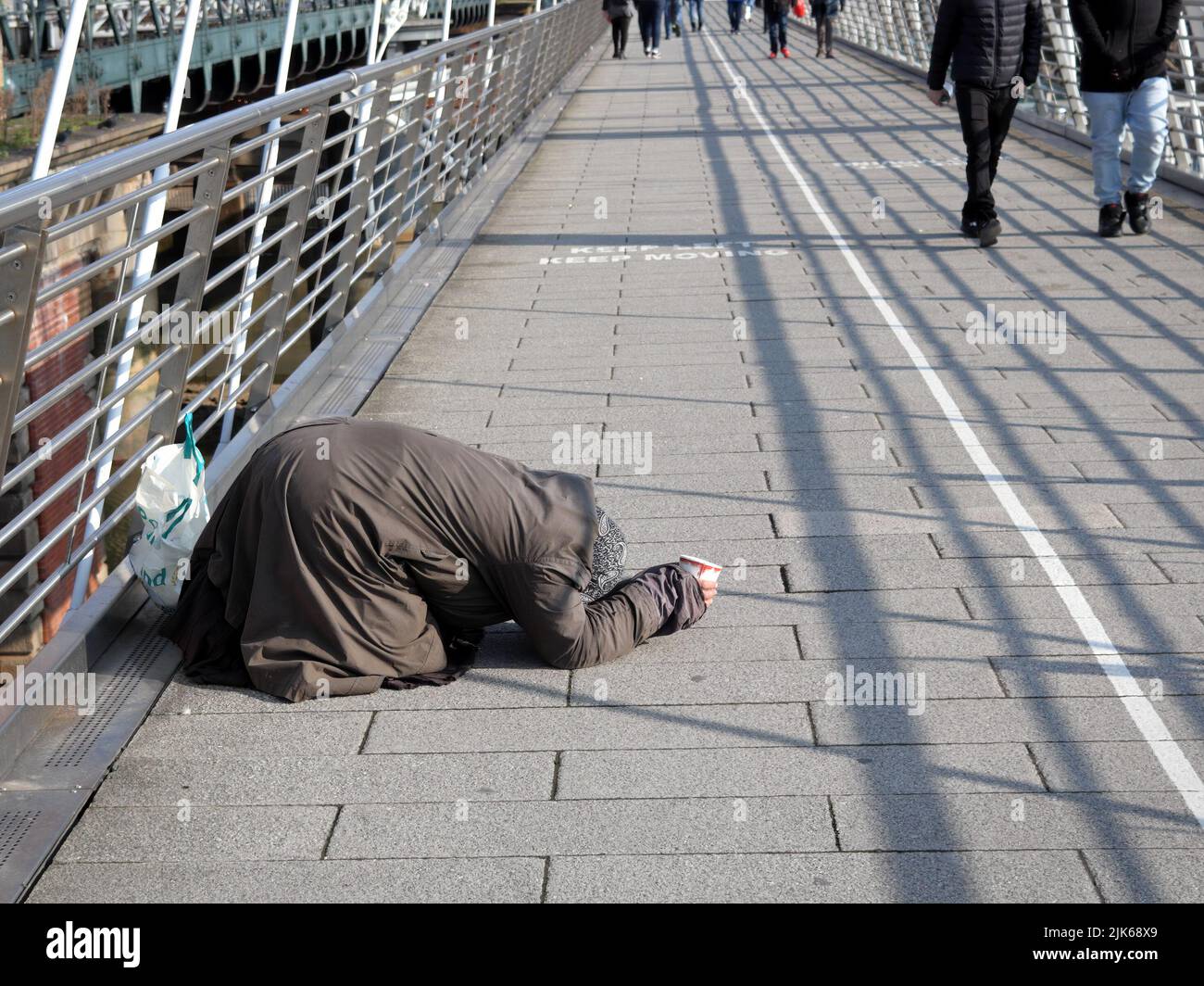 London, Großbritannien - 07. März 2021: Ältere arme Frau, die auf der Golden Jubilee Bridge um Geld bettelt Stockfoto