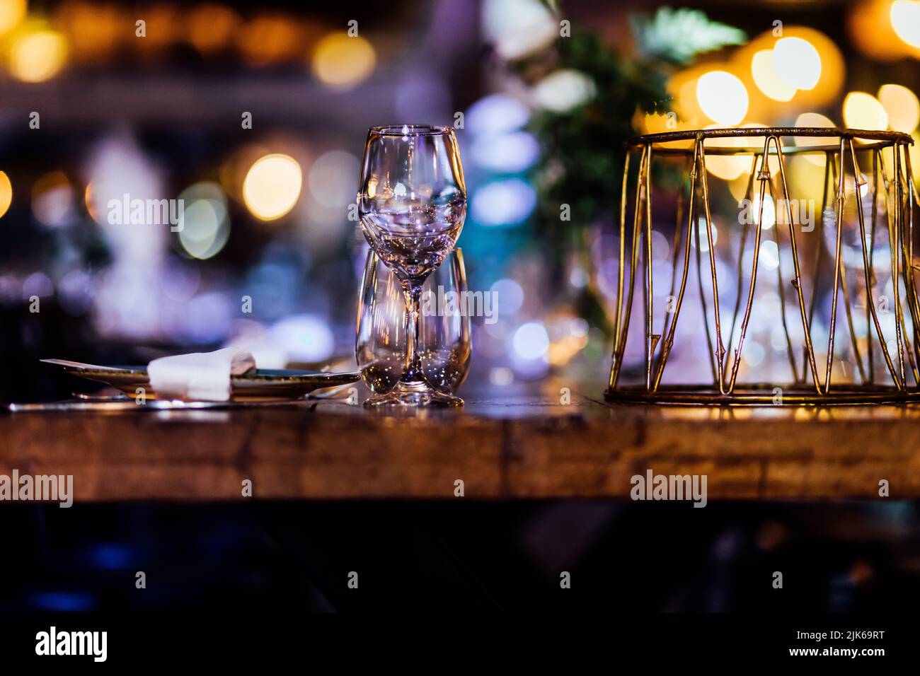 Luxuriöse Tischgedecke für feines Essen mit und Gläsern, Gießen von Wein ins Glas. Schöner unscharfer Hintergrund. Vorbereitung auf die Feiertagshochzeit. Extravagant Stockfoto