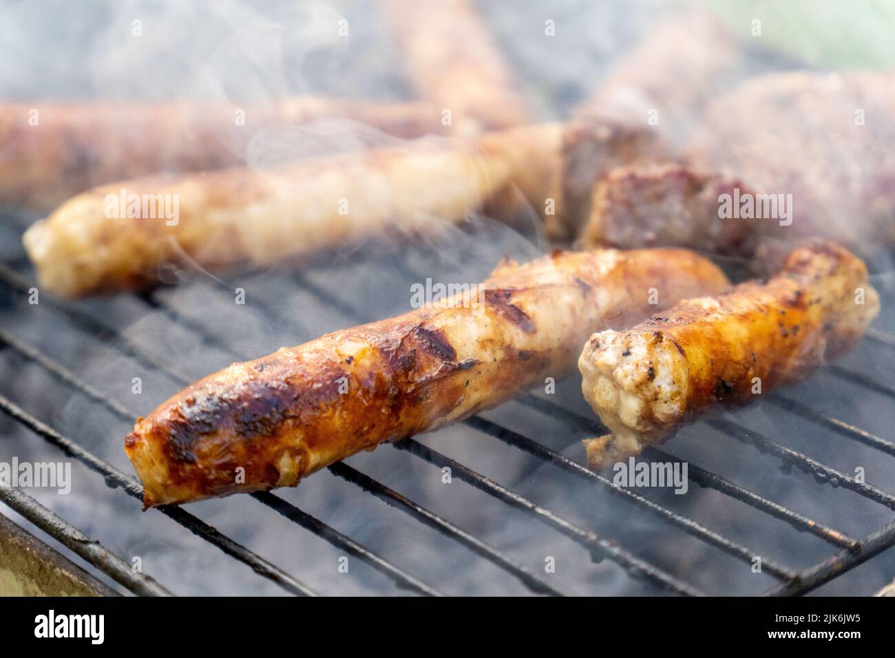 Nahaufnahme von Fleischwürsten auf dem Grill Stockfoto