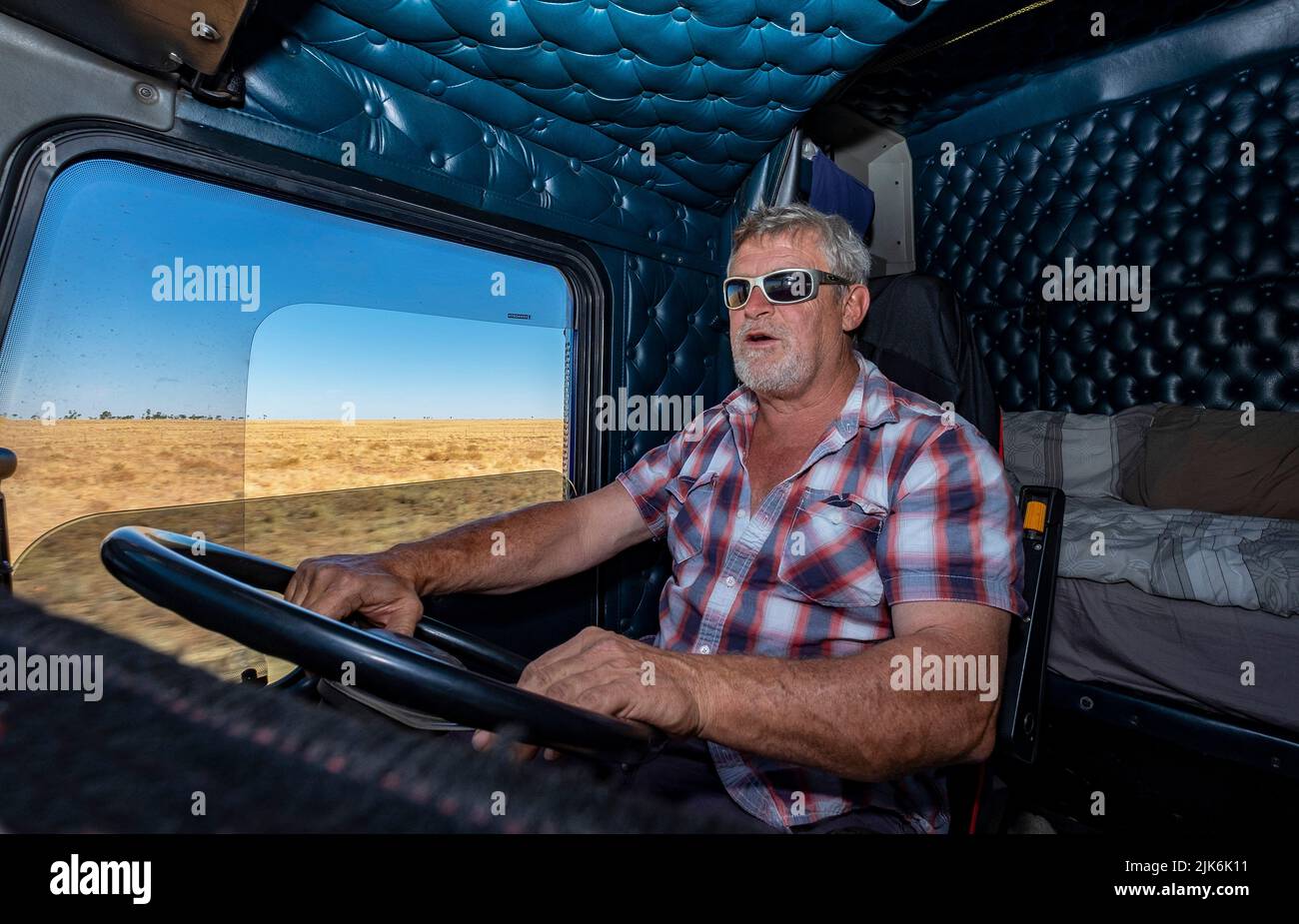 Peter Gaudry, ein LKW-Fahrer mit großer Distanz, am Steuer seines Doppelanhänger-Lkw B, der im australischen Northern Territory unterwegs ist Stockfoto