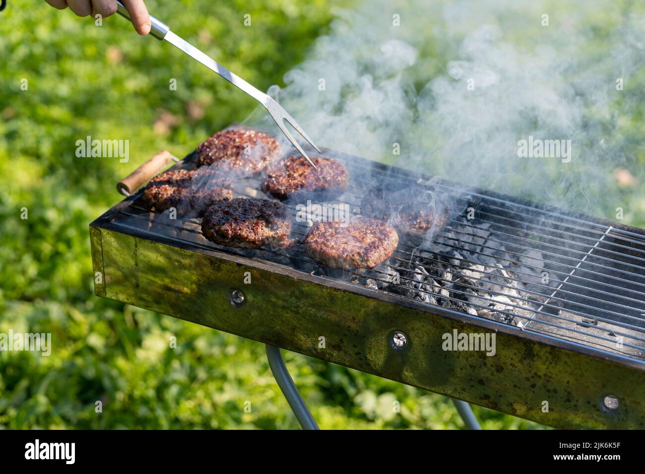 Nahaufnahme von Fleisch auf dem Grill bei Tageslicht, Hamburger Stockfoto
