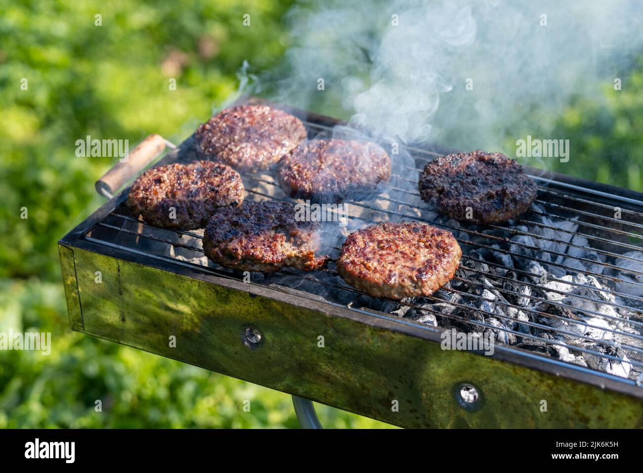 Nahaufnahme von Fleisch auf dem Grill bei Tageslicht, Hamburger Stockfoto