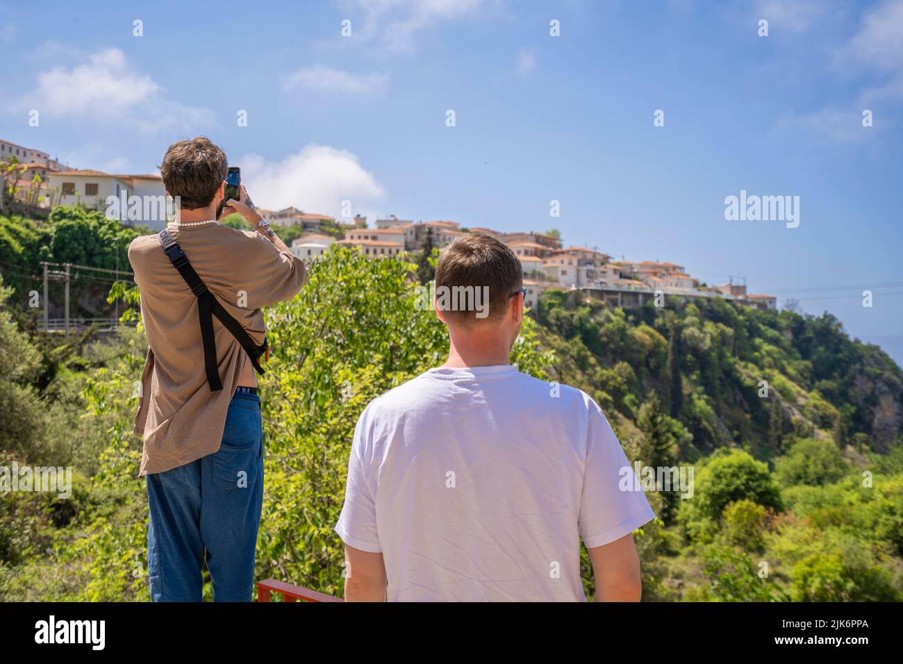 Llogara Albanien - 12.07.2021: Junge glückliche Touristen beobachten die Altstadt in albanien Stockfoto