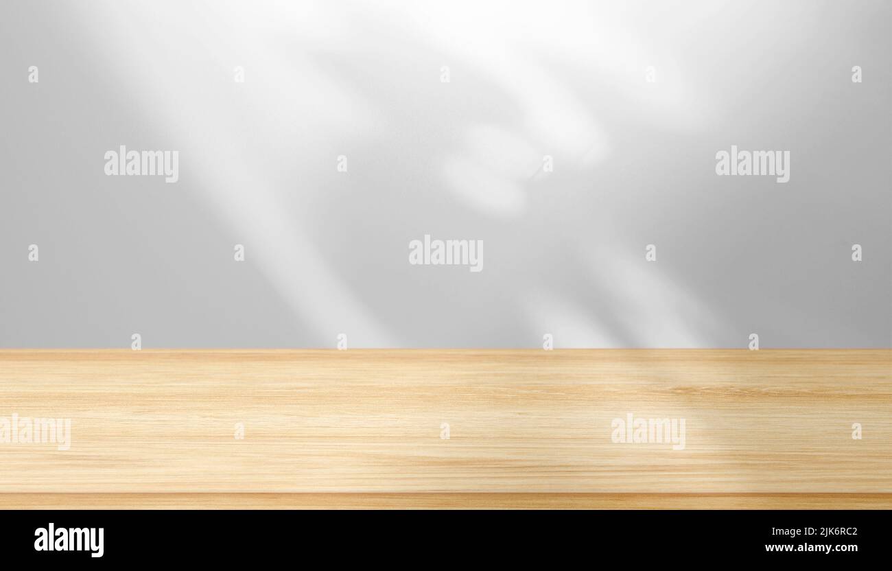 Blanke braune Tischplatte, Regal vor der Wand mit abstrakten Schatten, Licht Stockfoto