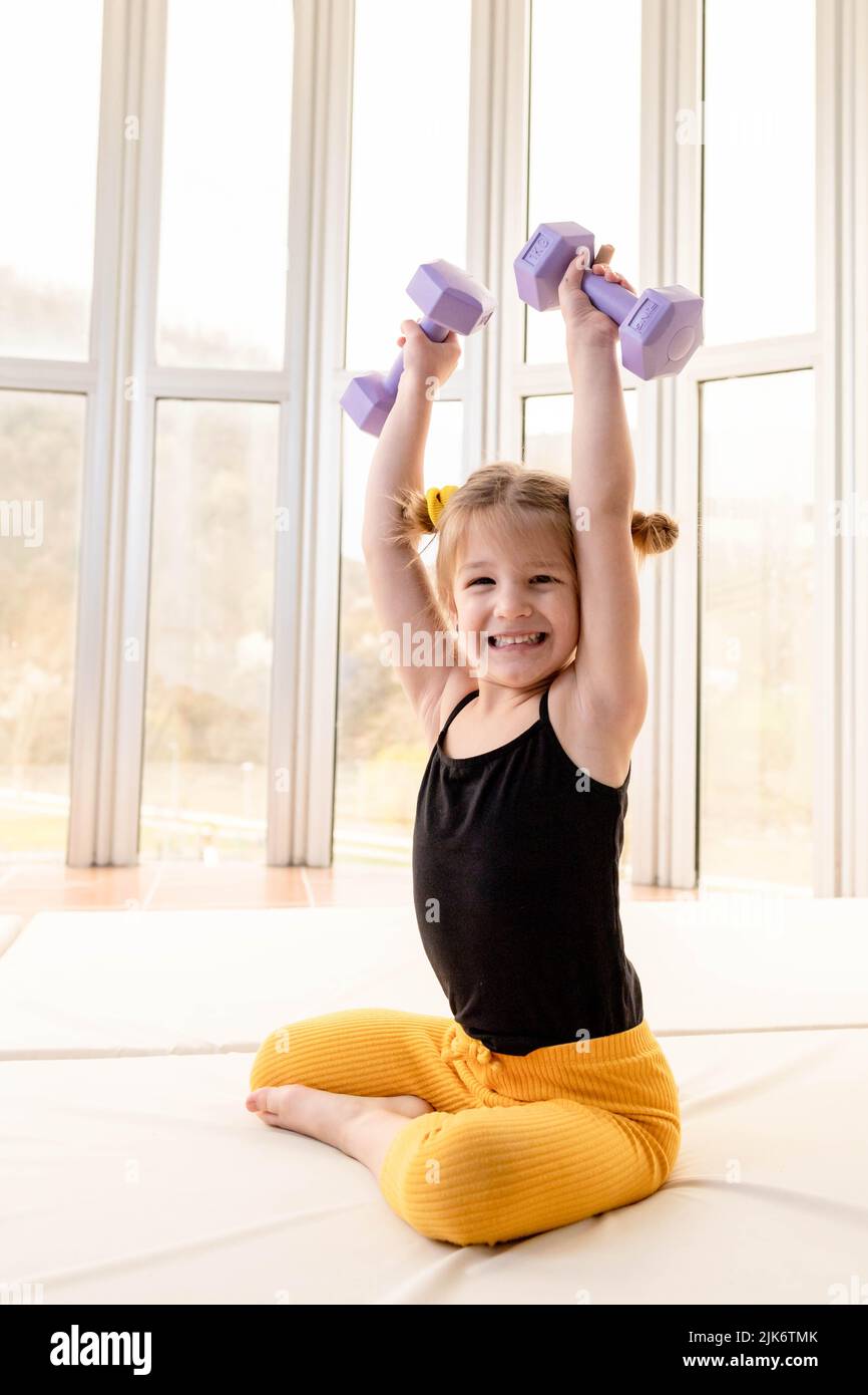 Kleine blonde Mädchen Heben Hanteln, Spaß haben Stockfoto