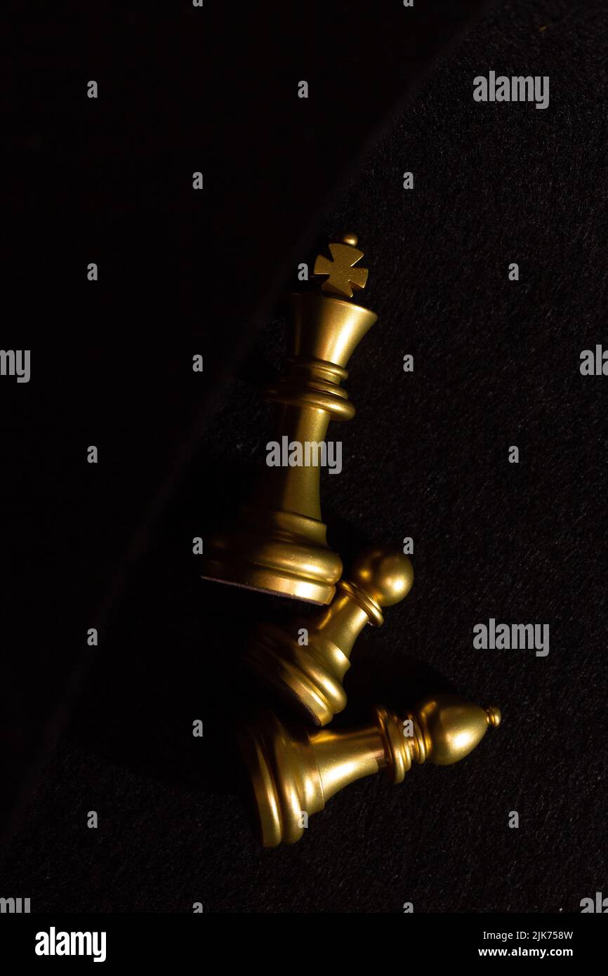 goldene Schachfiguren liegen auf einem schwarzen Hintergrund von oben Stockfoto
