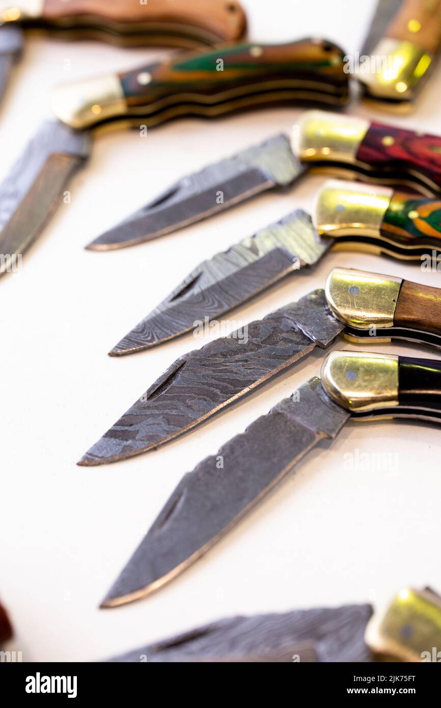 Verschiedene Messer und Lederetuis auf weißem Hintergrund Stockfoto