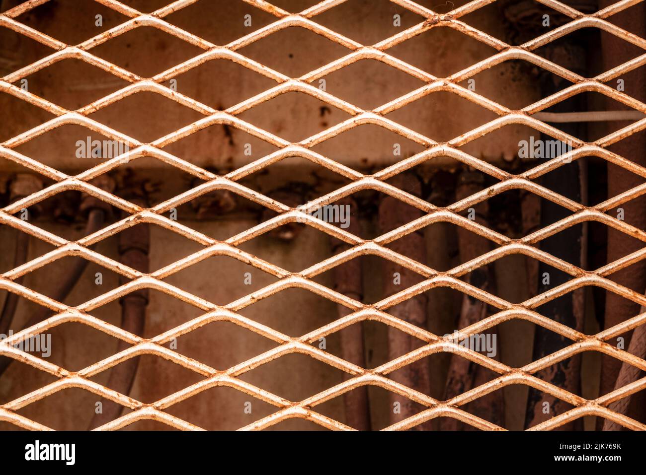 Industrielle Hintergrundtextur, eine Nahaufnahme des rostigen rhombischen Blechgitters eines alten Bergbaufahrzeugs Stockfoto