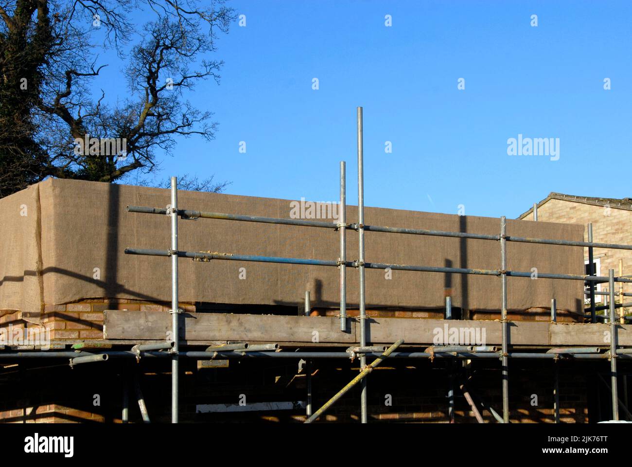 Hessisch umwickelt neue Mauerwerk im Hausbau, um im Winter vor Frost über Nacht zu schützen Stockfoto