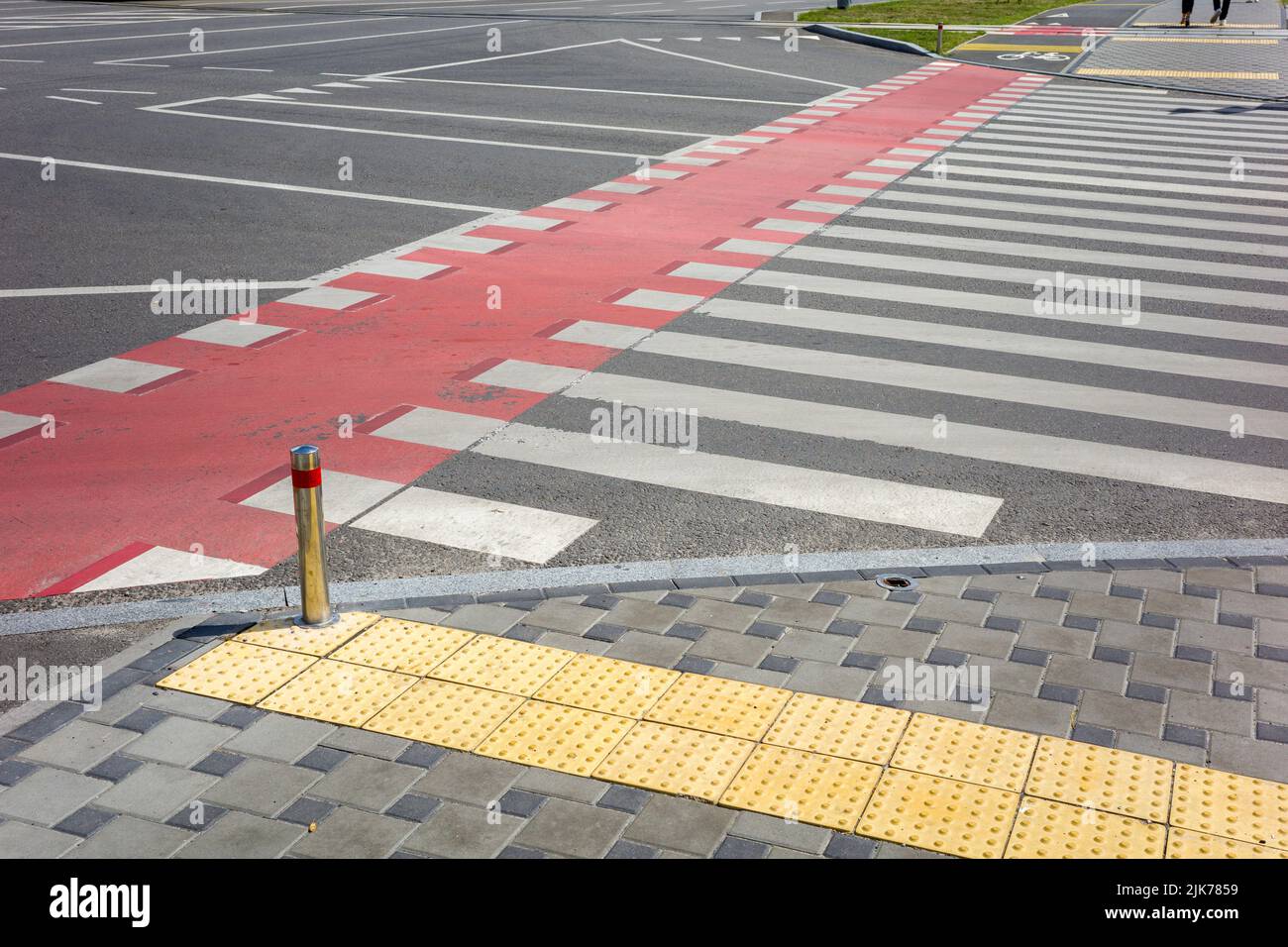 Fußgängerüberweg mit Zähnen und roten Markierungen für die Bewegung von Fahrrädern auf der Fahrbahn Stockfoto