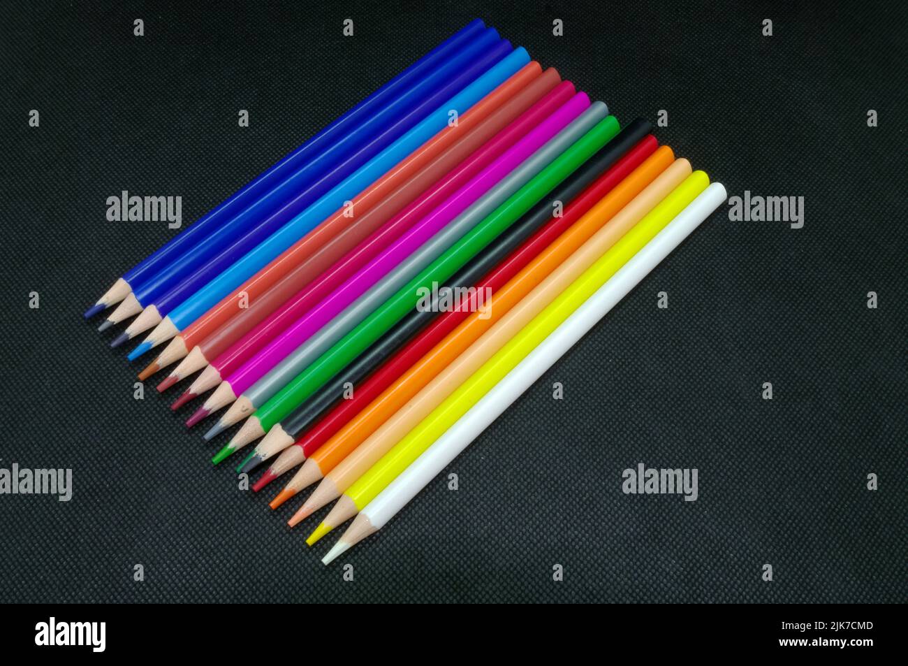 Malen und Zeichnen: Verschiedene Farbstifte übersichtlich parallel vor schwarzem Hintergrund angeordnet Stockfoto