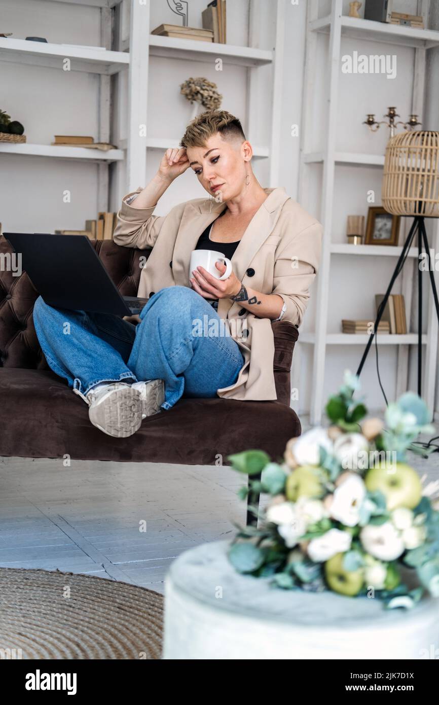 Eigenes Unternehmen Gründen. Junge trendige Frau plant neues Projekt mit Papieren und Laptop im Heimbüro Stockfoto