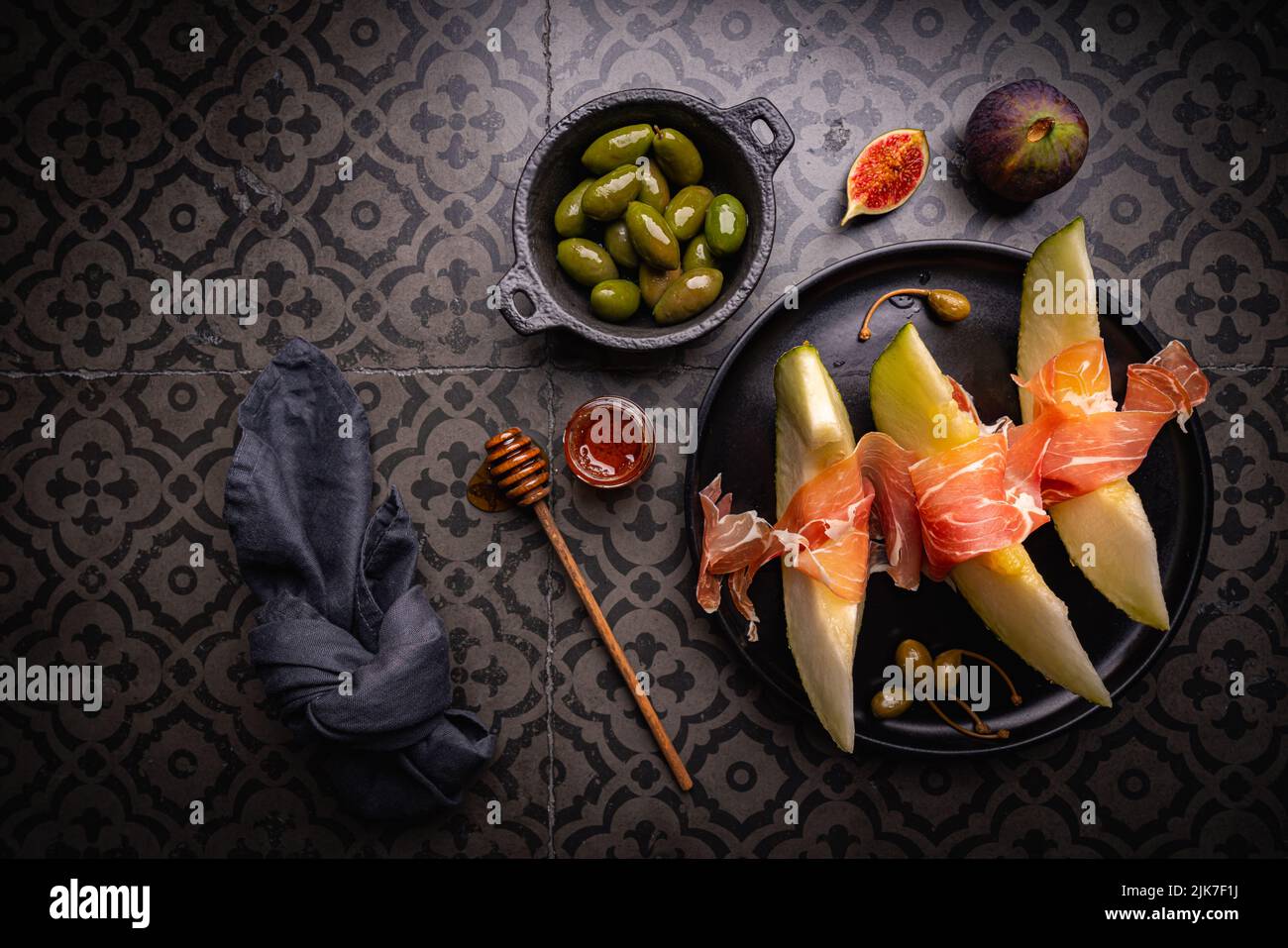 Jamon serrano, Schinken oder Prosciutto mit Melone und Oliven, eine ...
