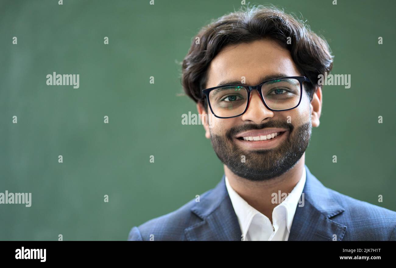 Lächelnder junger indischer Geschäftsmann in Anzug und Brille. Kopfbild im Porträt Stockfoto