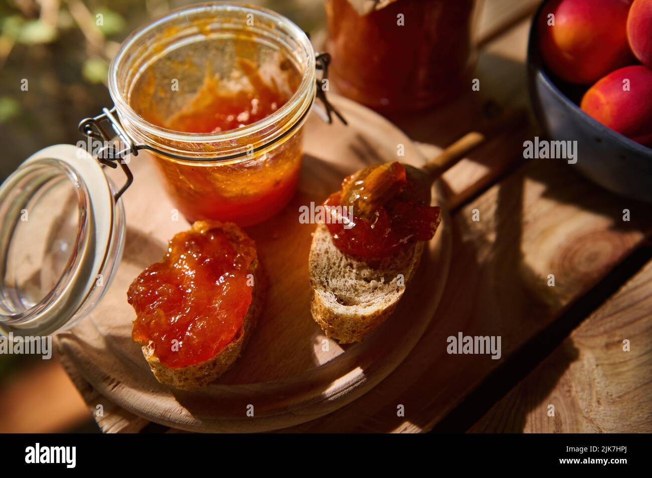 Draufsicht auf hausgemachte Aprikosenmarmelade, Scheiben Vollkornbrot auf einem Holzbrett. Konserven, süßes Dessert. Stillleben Stockfoto Draufsicht auf hausgemachte Aprikosenmarmelade, Scheiben Vollkornbrot auf einem Holzbrett. Konserven, süßes Dessert. Stillleben Stockfoto