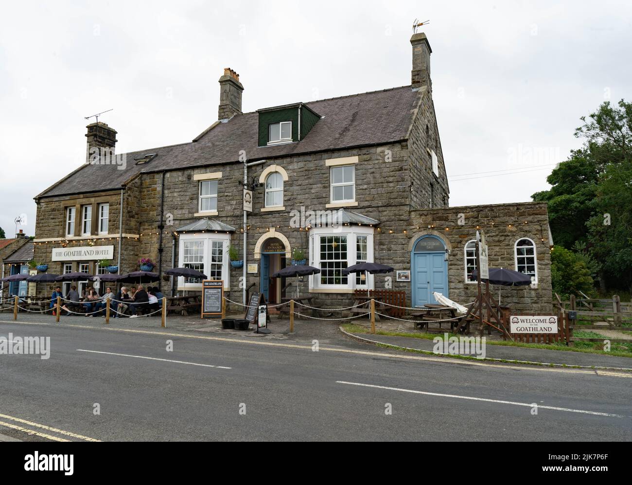 Traditioneller Yorkshire Stone Pub The Goathland Hotel mit Sitzgelegenheiten im Freien und blau lackierter Tür Stockfoto