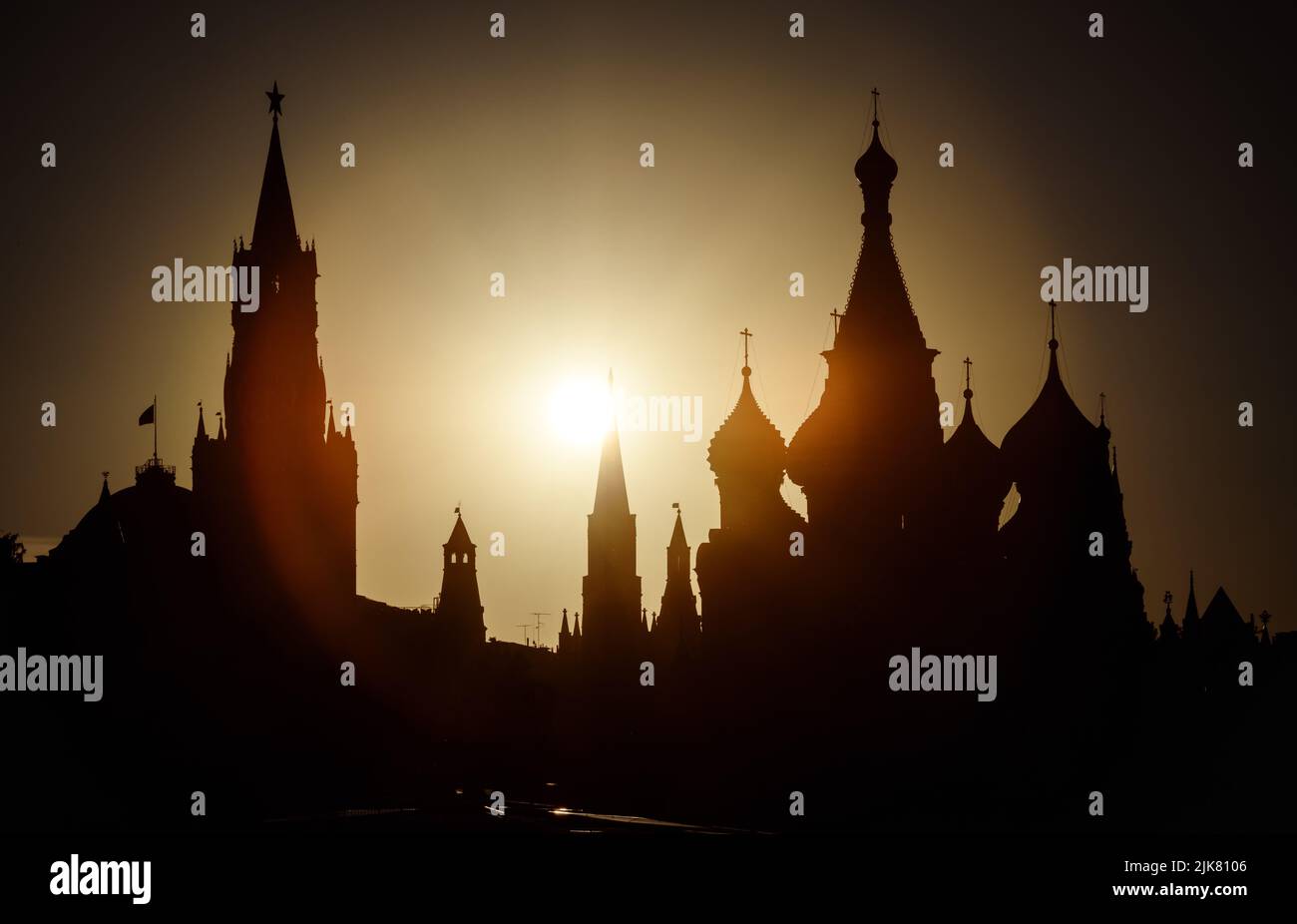 Moskauer Kreml und Basilius-Kathedrale bei Sonnenuntergang, Russland. Szenerie des Stadtzentrums von Moskau und Sonne am Sommerabend. Silhouetten von Moskauer Wahrzeichen in Stockfoto