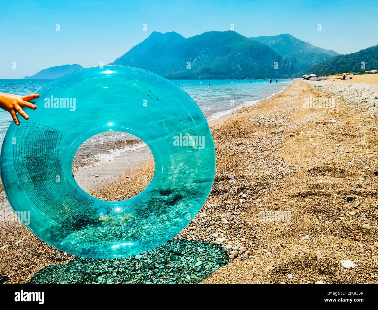 Blauer aufblasbarer Schwimmring und Sonnenbrillen am Strand. Stockfoto