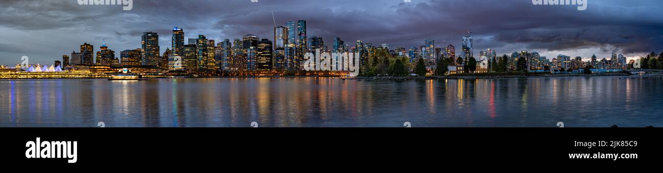 Ein Panorama-Blick auf die Skyline der Stadt, die bei Nacht in Vancouver, British Columbia, Kanada, beleuchtet wird. Stockfoto