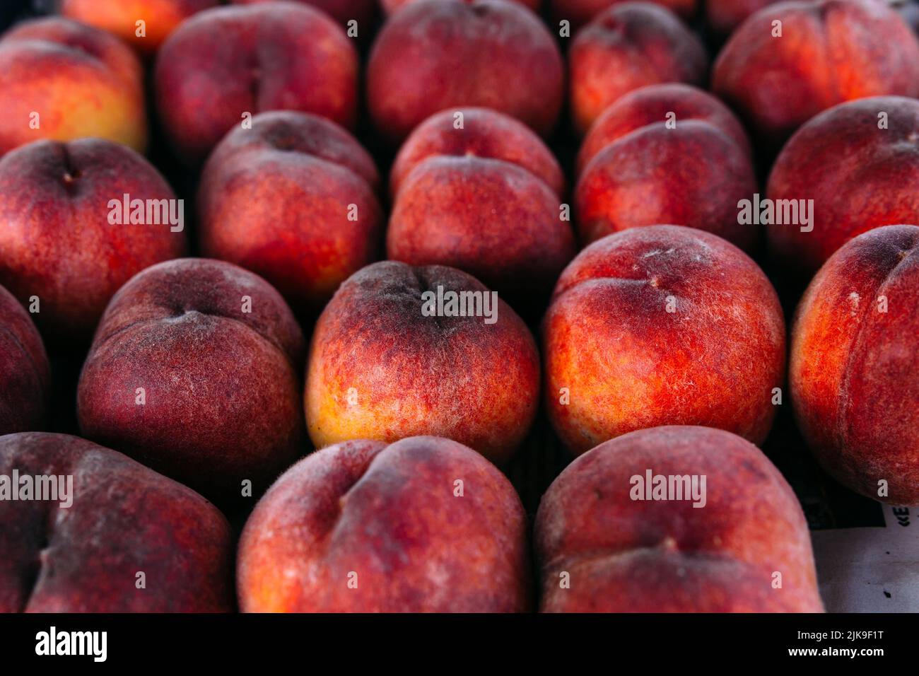 Leuchtend saftige rote Pfirsiche auf einem Bauernmarktstand Stockfoto