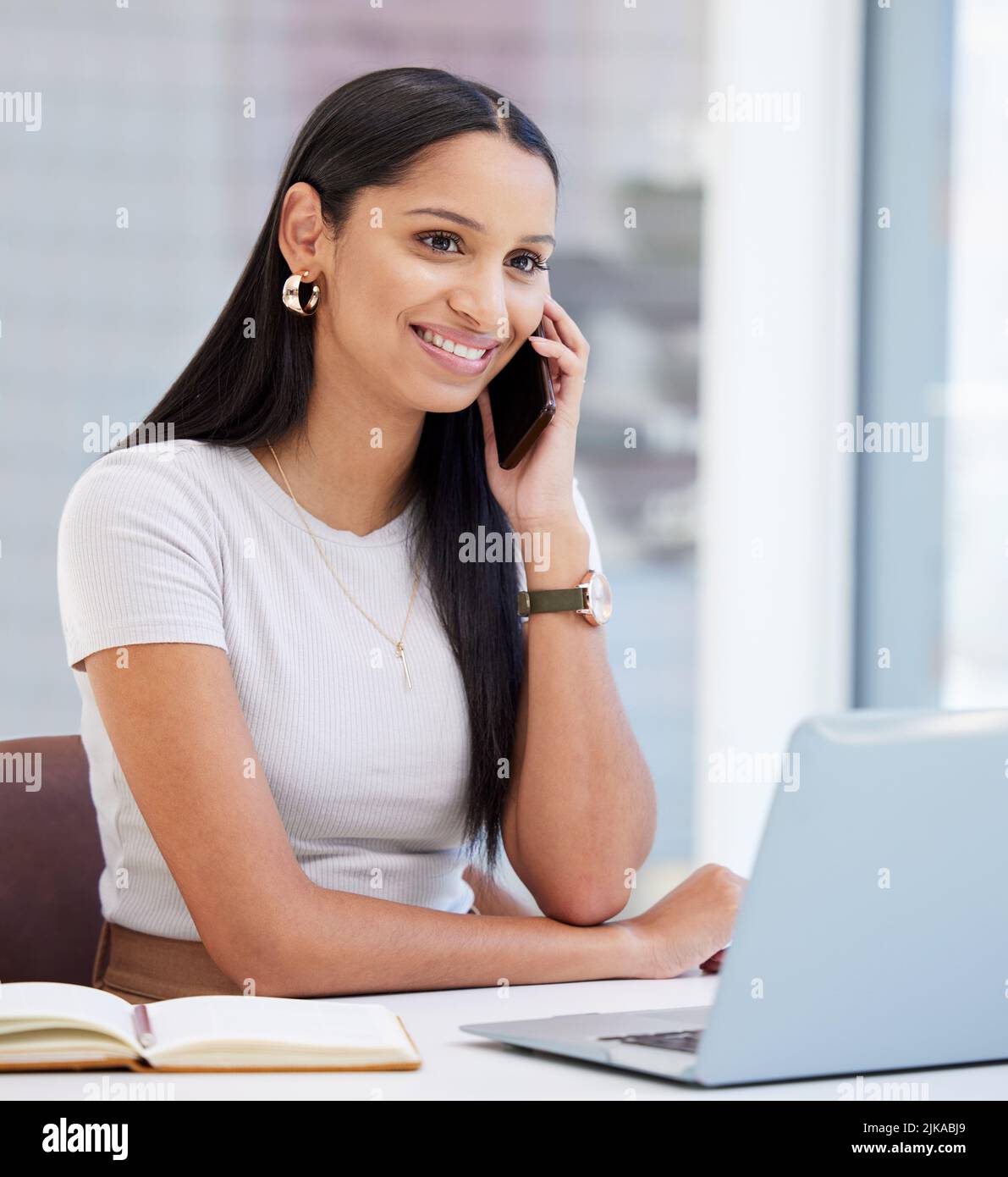 Ich bin so froh, Ihre Stimme zu hören. Eine junge Geschäftsfrau nutzt ihr Smartphone bei der Arbeit. Stockfoto