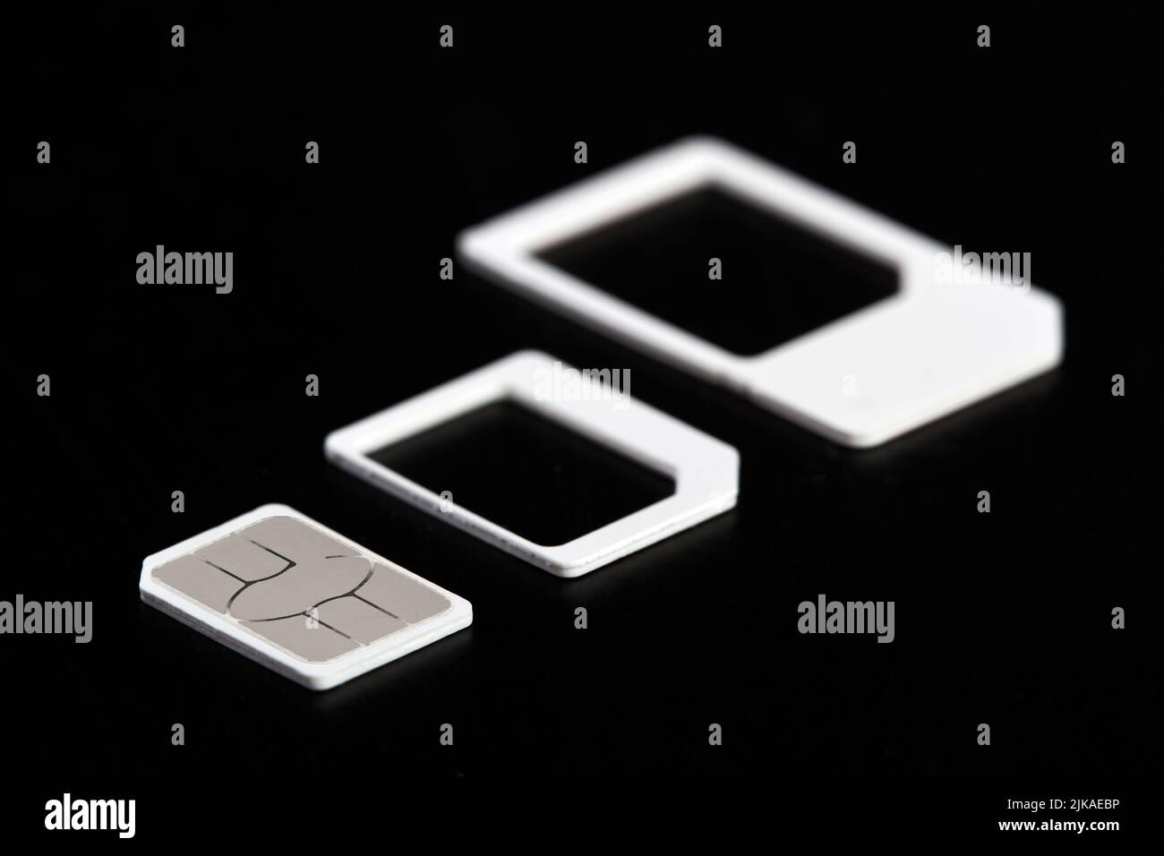 Nano-SIM-Karte aus sim-Kartenadaptern auf dunklem Hintergrund extrahiert Stockfoto