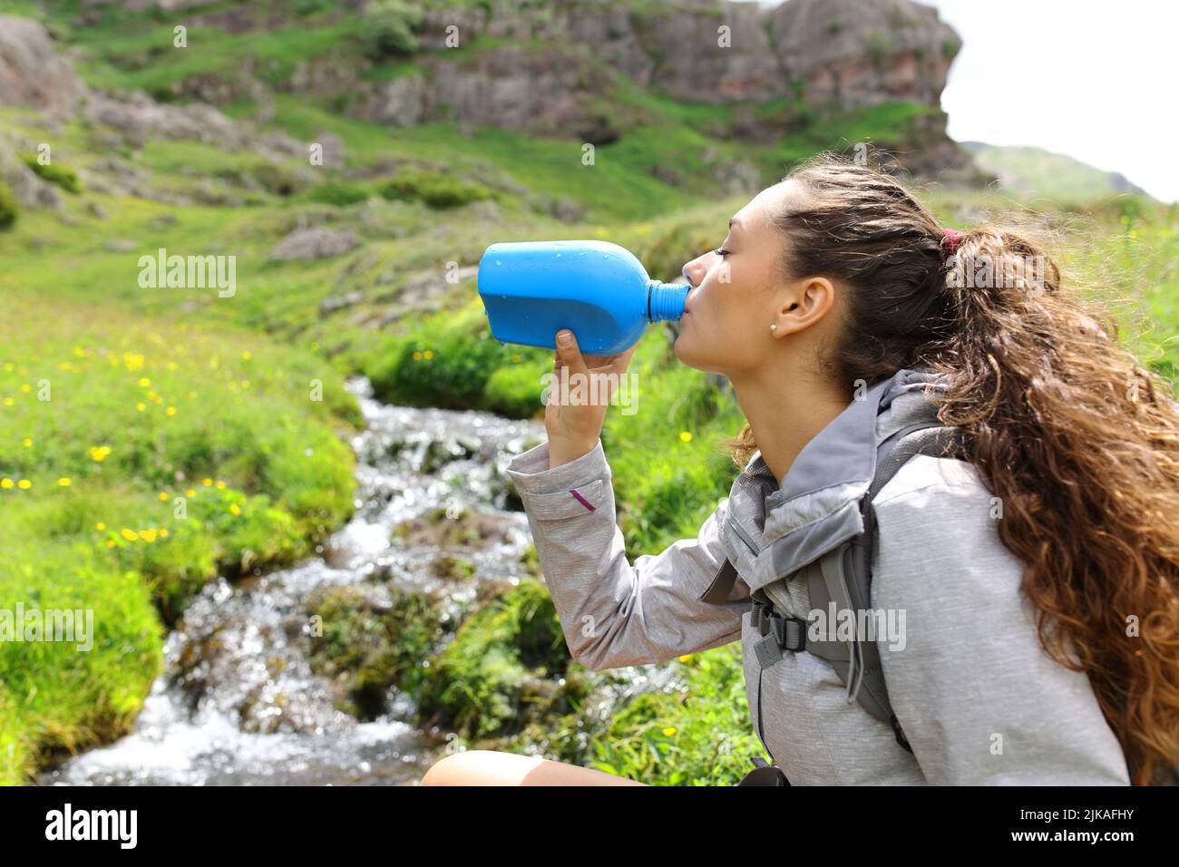 Seitenansicht Porträt eines Wanderers, der in einer Bergmannschaft Wasser aus der Kantine trinkt Stockfoto