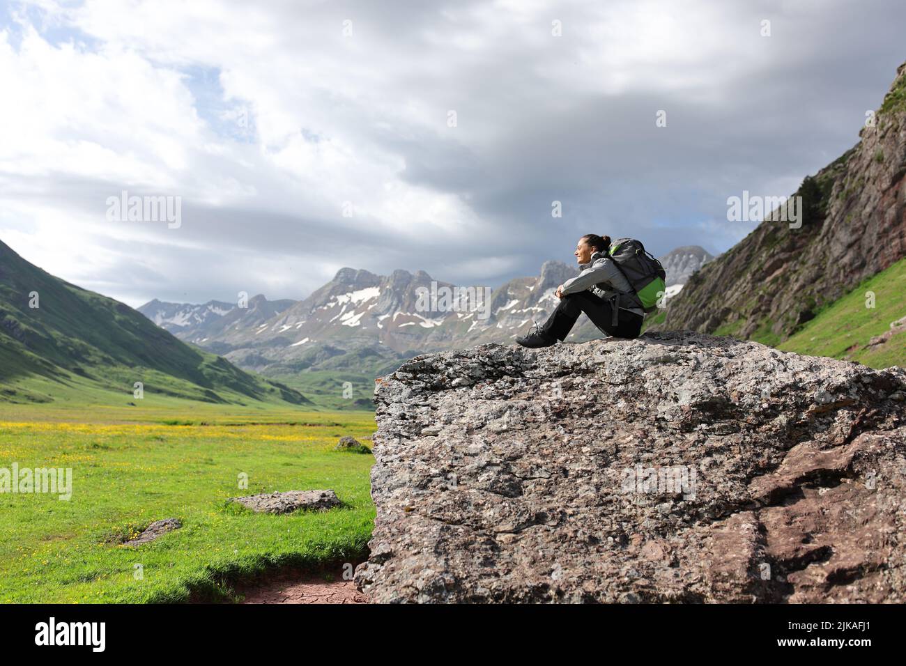 Wanderer ruhen sich aus und betrachten die Aussicht auf einem Felsen im Berg mit einer wunderschönen Landschaft im Hintergrund Stockfoto