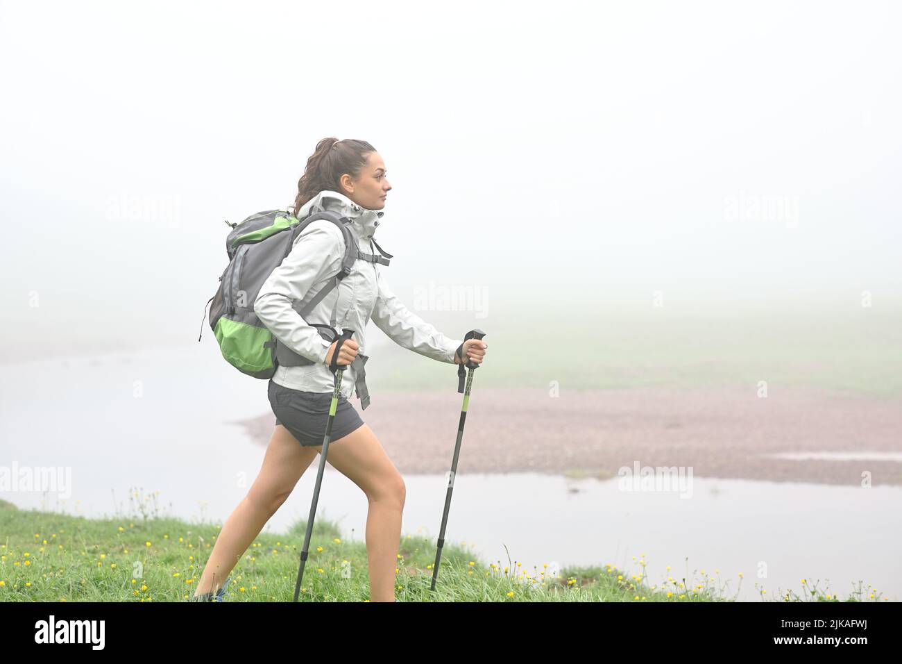 Seitenansicht Porträt eines Trekkers, der einen nebligen Tag in den Bergen spazierengeht Stockfoto