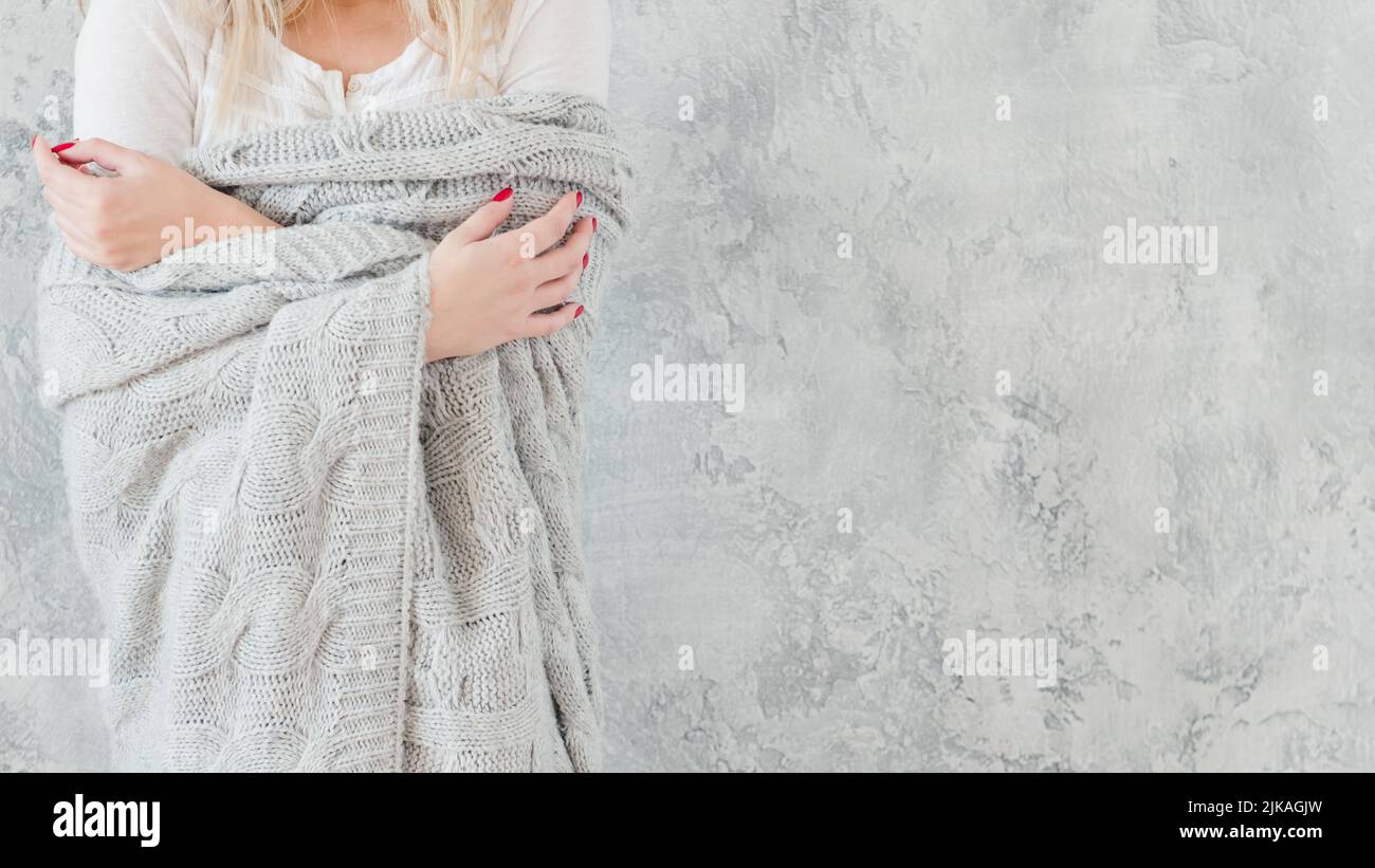 Verletzliche empfindliche Frau grau gestrickte Decke Stockfoto