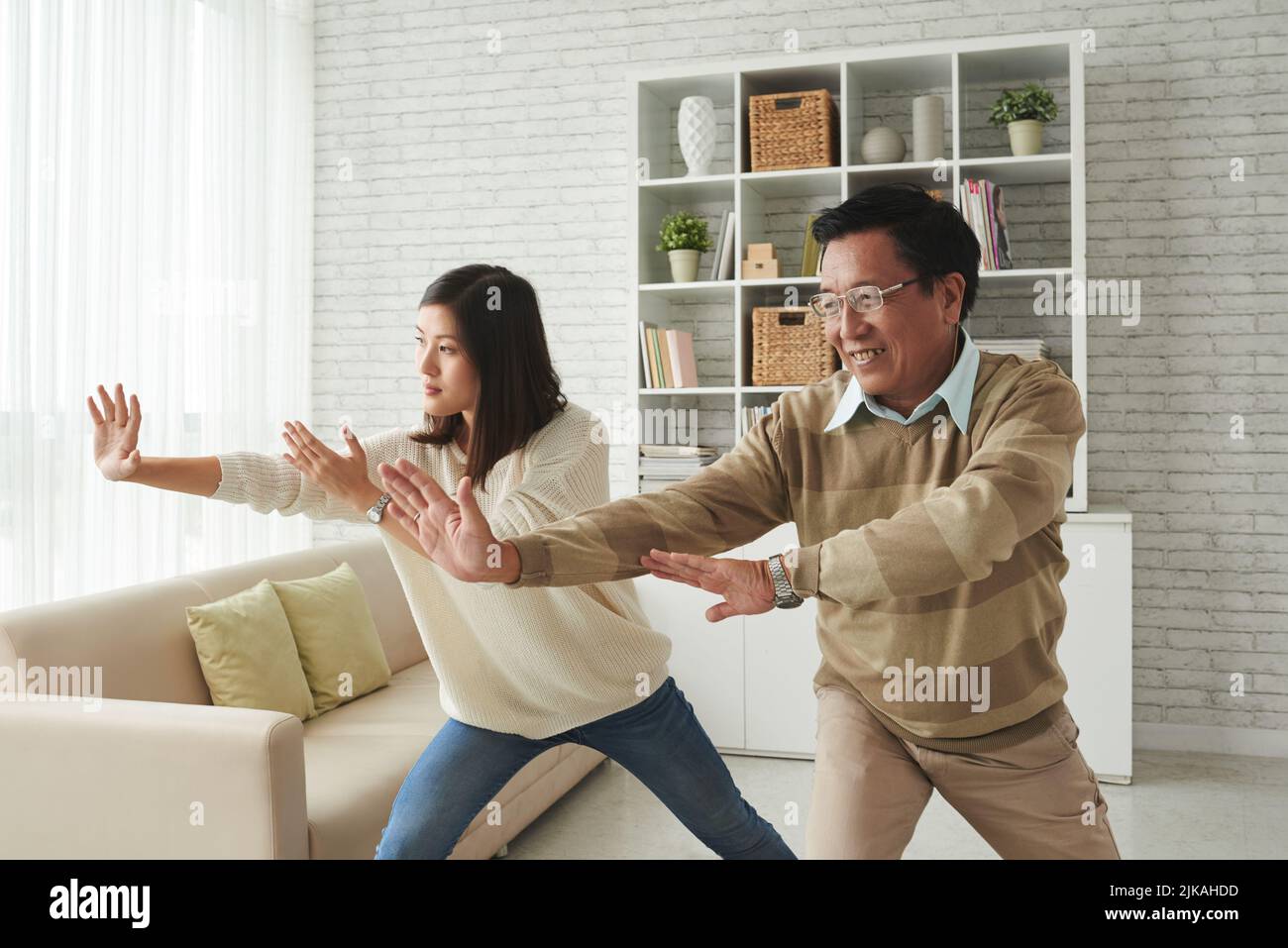 Mutter und Vater genießen die thai-Chi-Praxis zu Hause Stockfoto