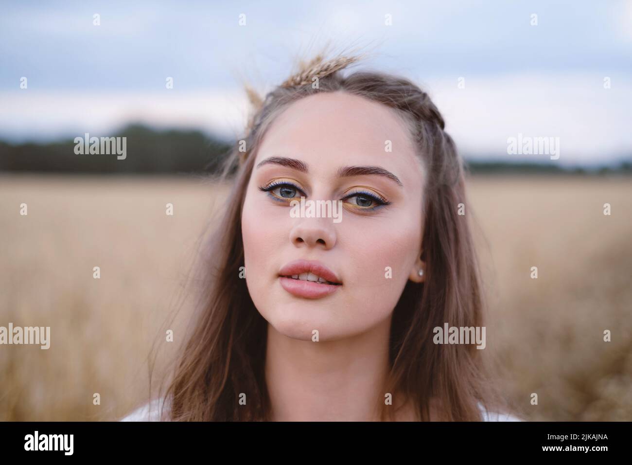 Schöne Frau auf Weizenfeld. Junge Frau mit Make-up Schönheit Porträt im Freien. Ukrainische landwirtschaftliche Flächen mit Roggen. Boho-Chic. Stockfoto