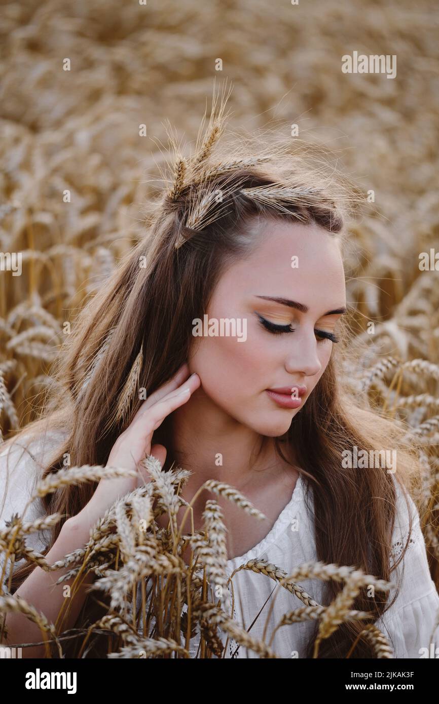 Schöne Frau auf Weizenfeld. Junge Frau mit Make-up Schönheit Porträt im Freien. Ukrainische landwirtschaftliche Flächen mit Roggen. Boho-Chic. Stockfoto