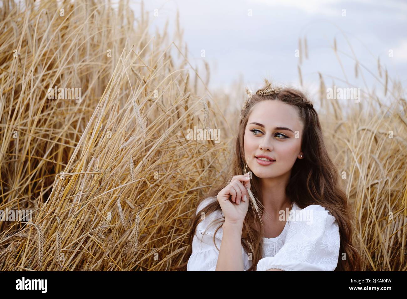 Schöne Frau auf Weizenfeld. Junge Frau mit Make-up Schönheit Porträt im Freien. Ukrainische landwirtschaftliche Flächen mit Roggen. Boho-Chic. Stockfoto