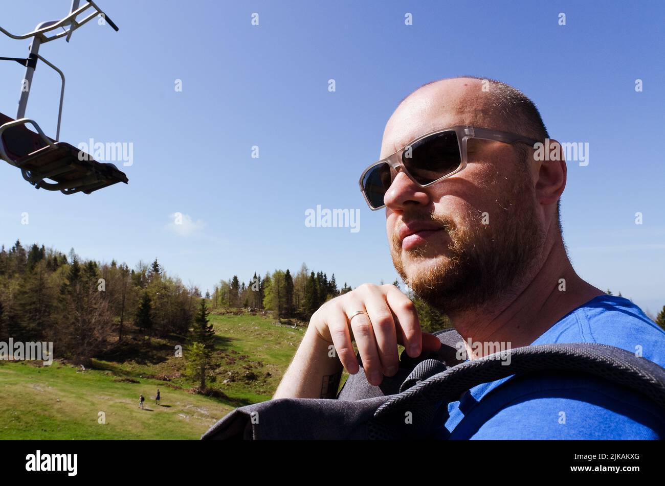 Der Mensch genießt den Blick auf das alpine Dorf in den Bergen. Velika Planina oder großes Weideplateau in den Kamnik Alpen, Slowenien. Stockfoto