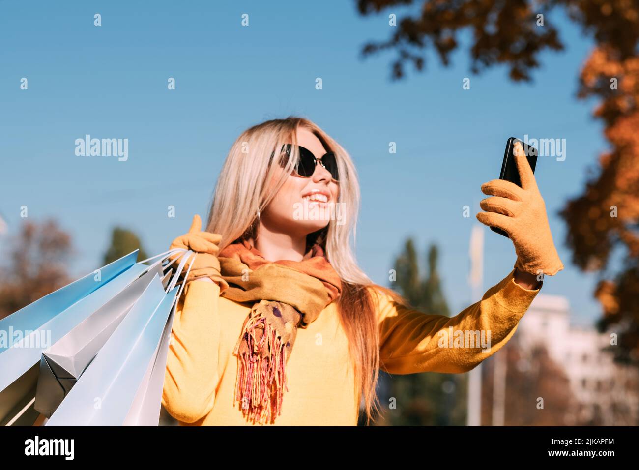 Fall Park Walk Einkaufstaschen Smartphone Selfie Stockfoto