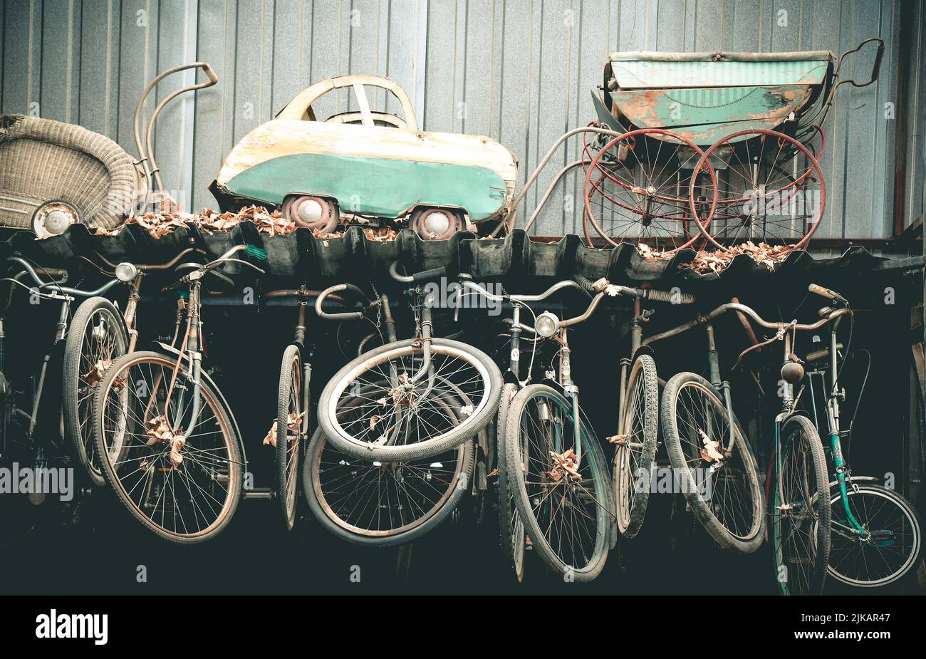 Sammlung sehr alter abgenutzter Kinderwagen und Fahrräder Stockfoto