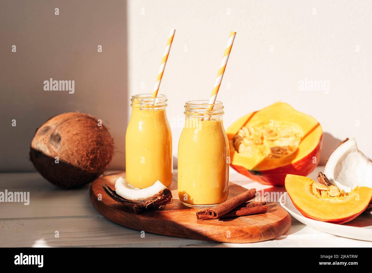 Kürbis und Kokosnuss-Smoothie in Flaschen mit Stroh. Gesundes, rohes veganes Essen. Nahaufnahme Stockfoto