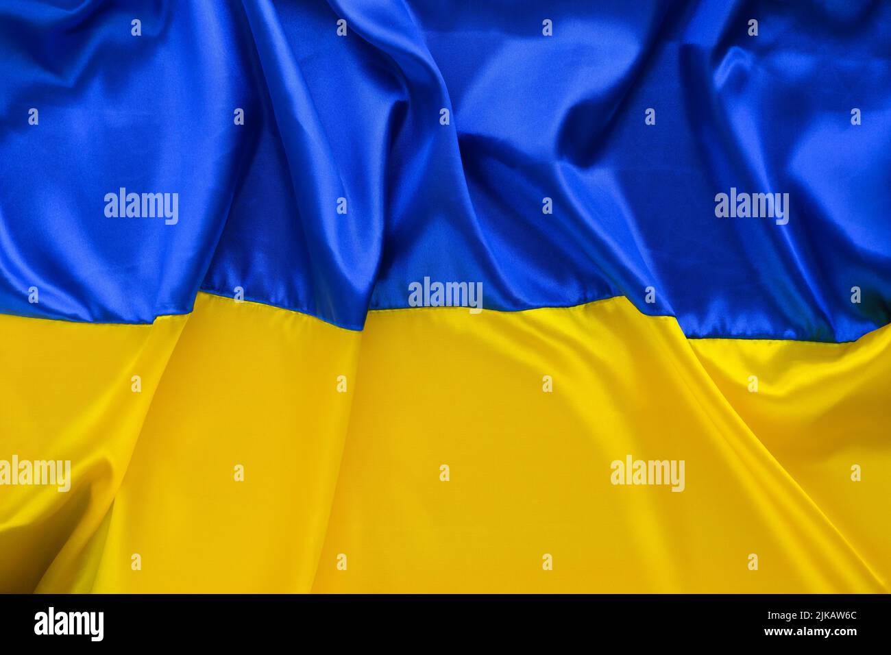 Fabric Wave Flagge der Ukraine, UA. Blaue und gelbe helle Farben. Nahaufnahme gekrümmter Texturhintergrund Stockfoto